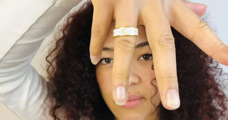 Femme portant bague blanche et doré à l'oor