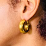 Femme portant à l'oreille gauche une créole épaisse plaque or Femme portant à l'oreille gauche une créole épaisse plaque or