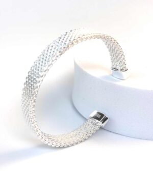 Bracelet jonc manchette en maille argent 925 pour femme présenté de profil sur socle blanc