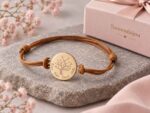 Bracelet arbre de vie personnalisé avec coffret Toimonbijou Bracelet cordon arbre de vie personnalisé posé sur une pierre grise avec coffret Toimonbijou